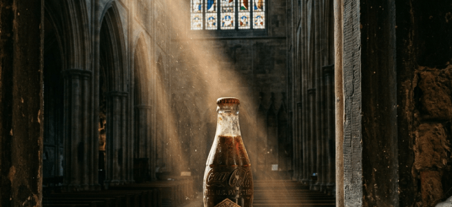 Vintage Coca-Cola glass bottle on stone ledge with light beam in cathedral